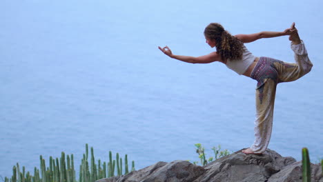con el fondo del océano azul profundo al atardecer, una mujer joven realiza yoga en una orilla rocosa, ejemplificando un estilo de vida saludable, armonía y el intrincado vínculo compartido entre los humanos y la naturaleza