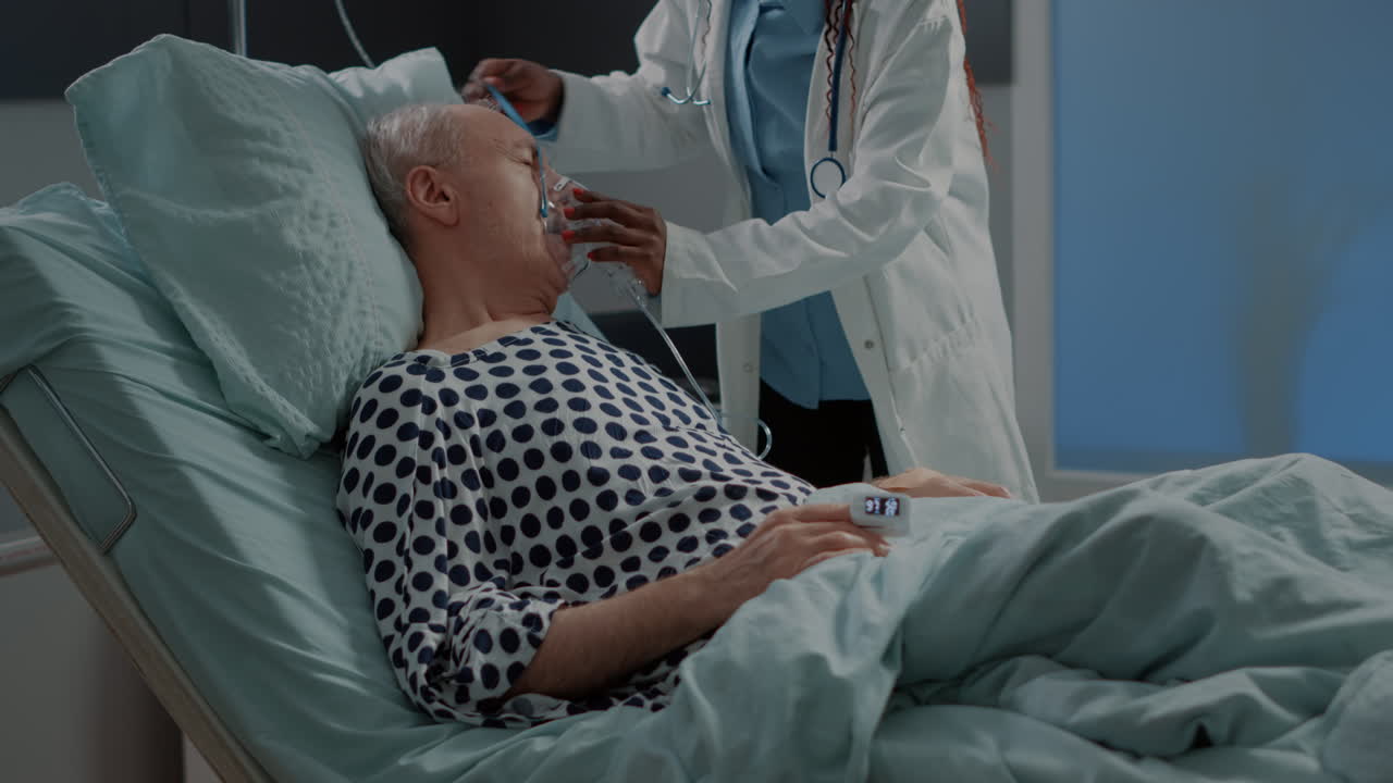 African american doctor helping sick patient in hospital ward