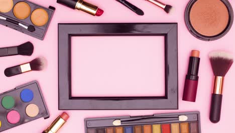 Make up products appear around black frame for text on pink theme. Stop motion