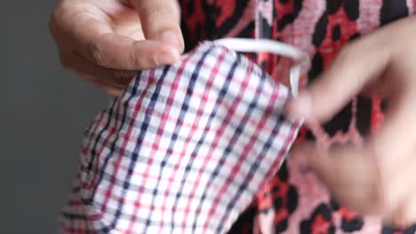 woman holding a checked fabric face mask