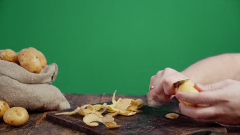 men hands peeling potatoes from the skin.