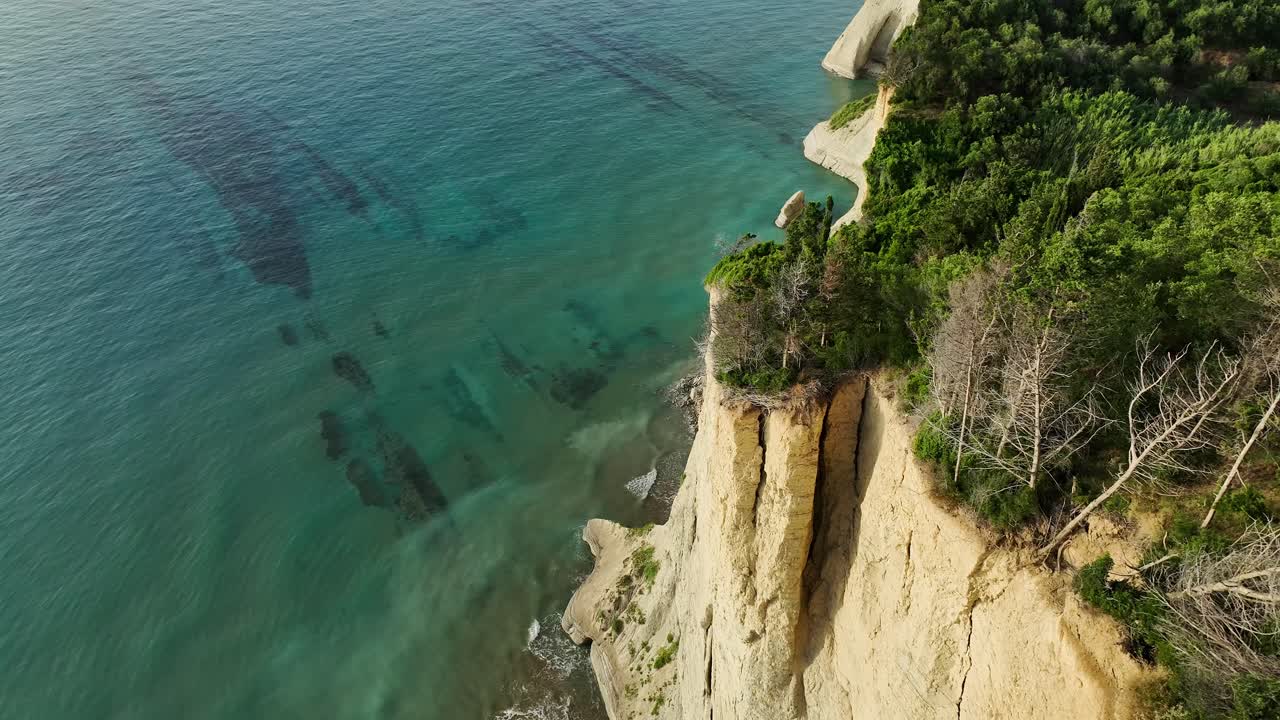los acantilados iluminados por el sol a lo largo de la costa de la isla de corfú, con vistas al mar jónico, vista aérea