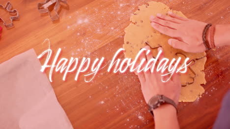 animation of happy holidays text over caucasian man baking in kitchen