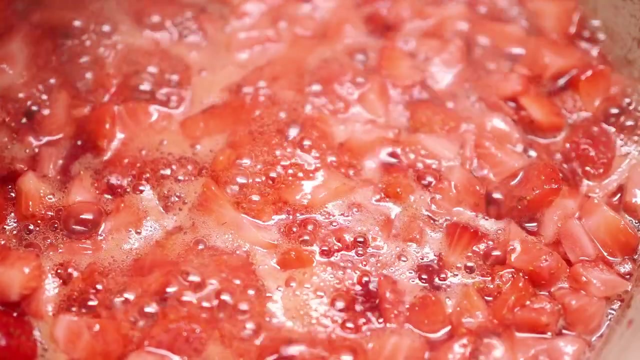 Fragole fresche che sobbollono in una pentola per fare la marmellata