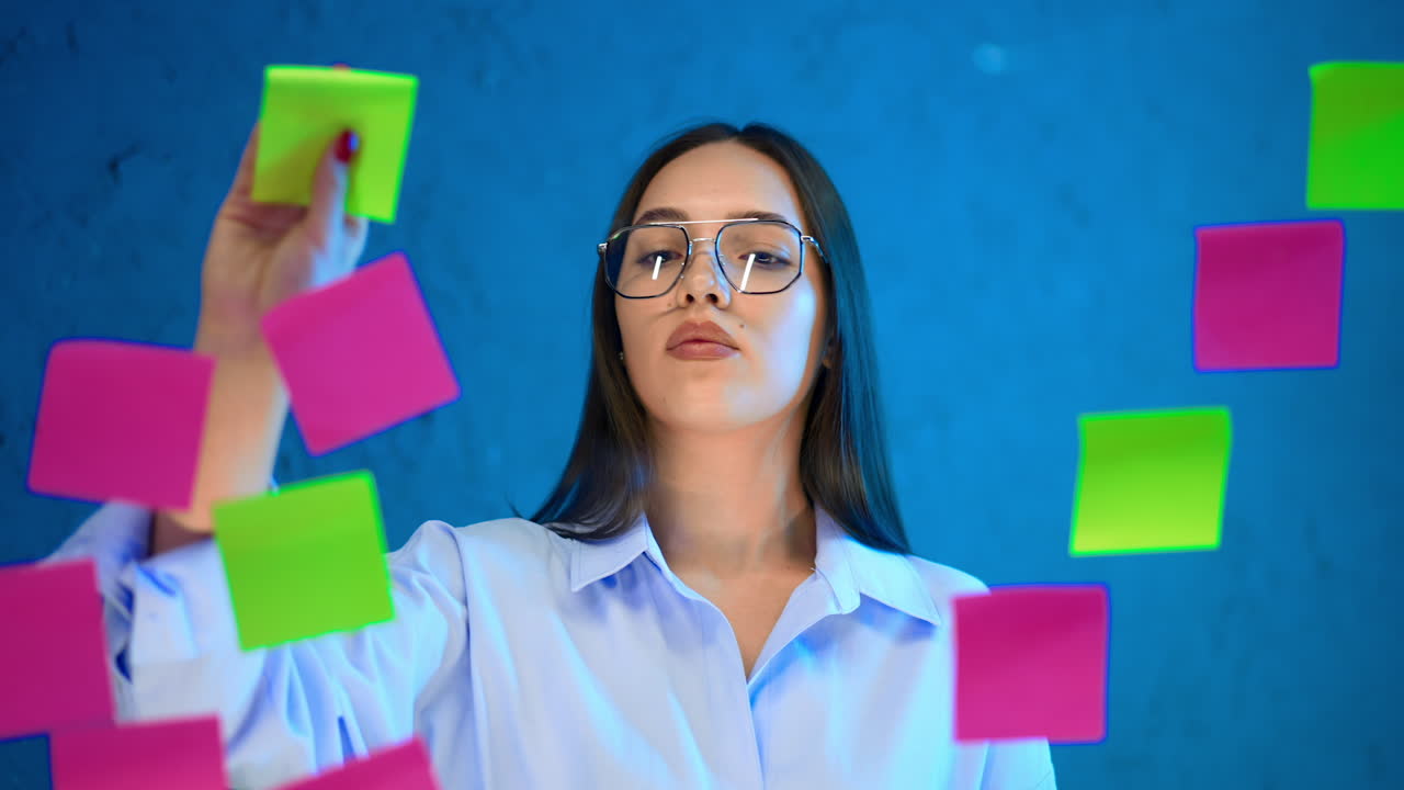 Serious female professional putting stickers on the glass board. Business and management concept.