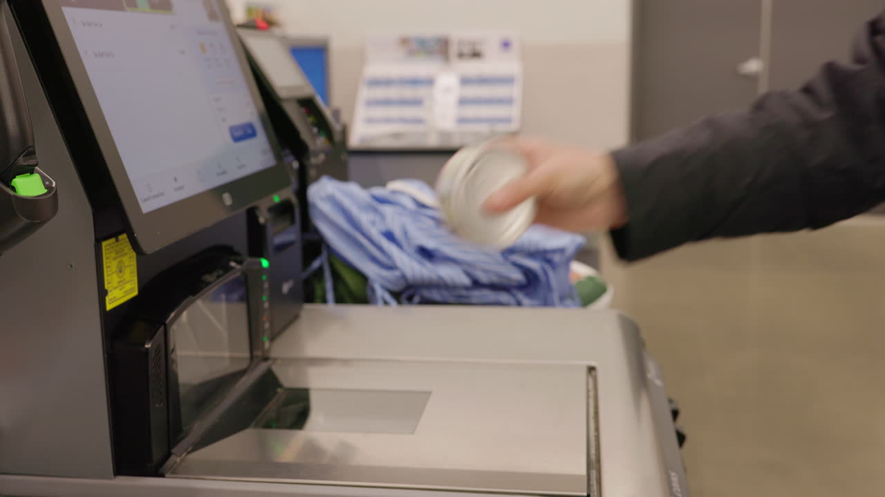 Cliente che scansiona alimenti in scatola alla cassa automatica del supermercato