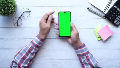 young man hand using smart phone on office desk