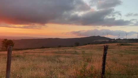 set of wind turbines spinning in middle of rural countryside at incredible sunset in spain