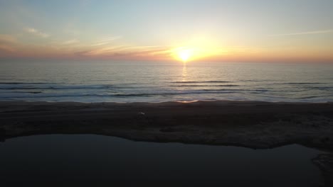 a beautiful aerial above a golden sunset over a generic ocean coast 2