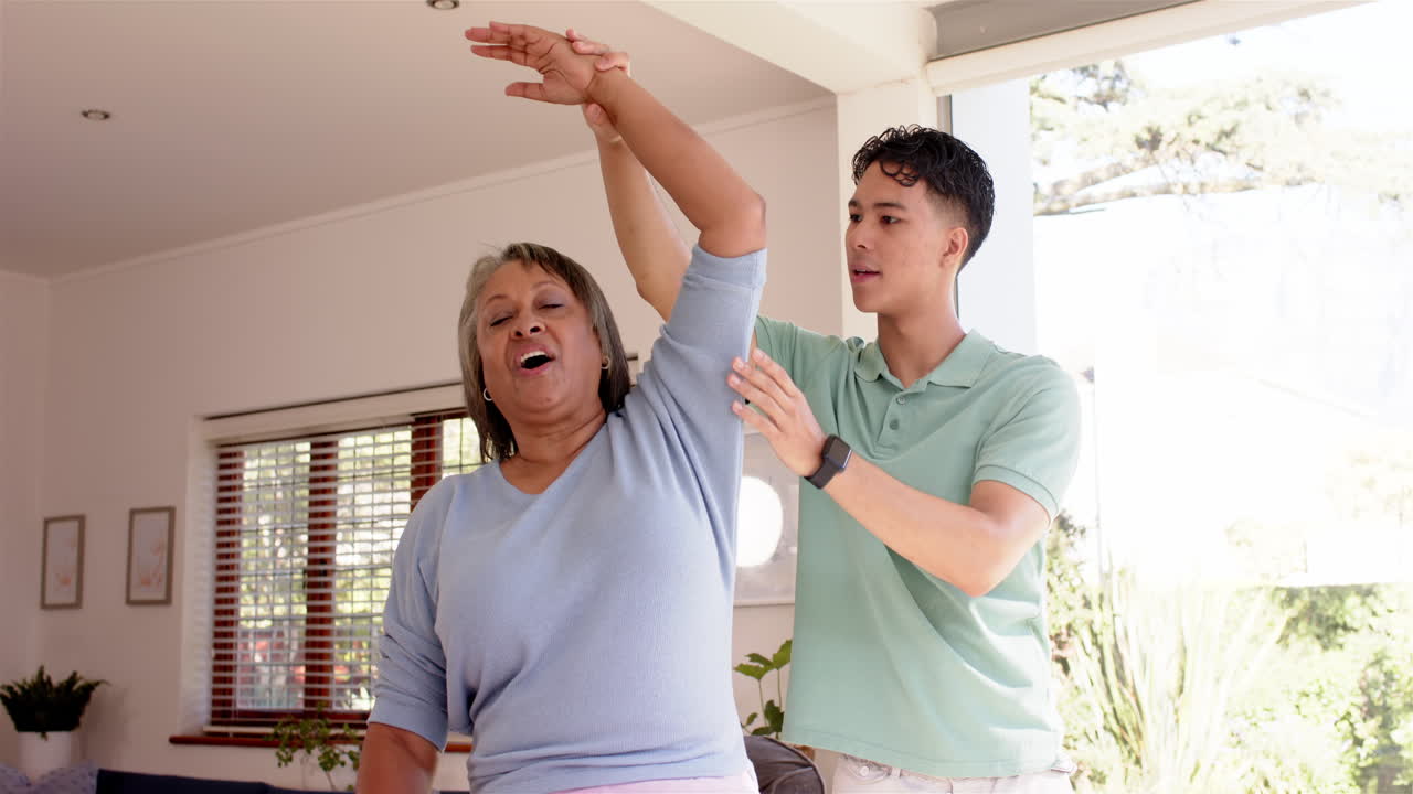 Assisting senior woman with arm exercises, physiotherapist in rehabilitation session