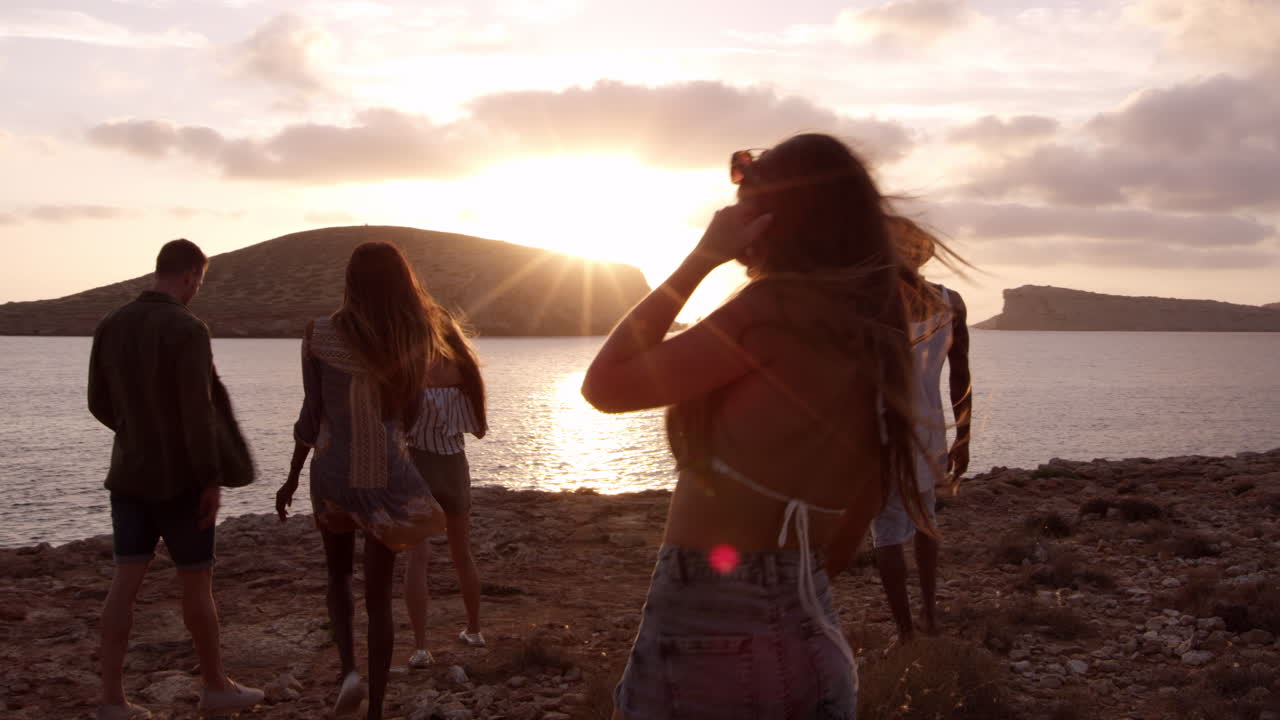 Amici che camminano su una scogliera che guardano il tramonto, girato su R3D