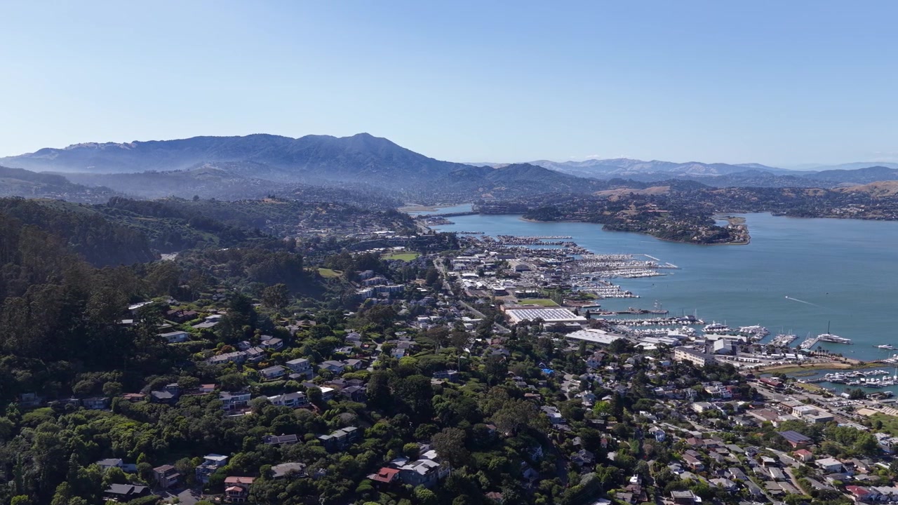 Una vista drone cattura la bellezza della costa di Sausalito, rivelando porti, dolci colline e aree residenziali annidate lungo l'acqua in questa distintiva destinazione della Bay Area