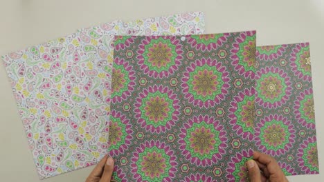 Inclinación-De-Un-Trozo-De-Papel-Adornado-Con-Adornos-De-Mandala-De-Lámina-Dorada-Brillante