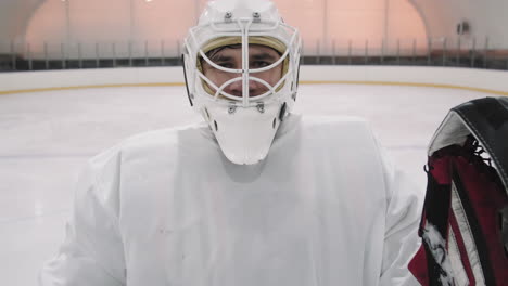 Portrait Of Goalie Putting On Helmet