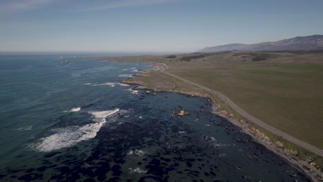 calm waves at pacific coast highway (highway 1) near cambria and san simeon in california, united states. aerial drone shot