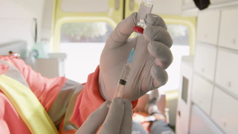 close up of an unrecognizable paramedic preparing a syringe and then injecting the shot to an american patient in the ambulance