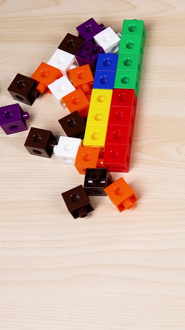 Hands organizing colorful cubes on a wooden surface