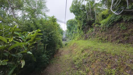 chairlifts ascend to the top of the hill at penang theme park, surrounded by lush greenery