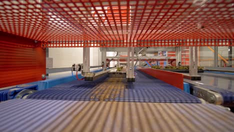 low shot beneath automated machinery within a vertical farm moving plants around