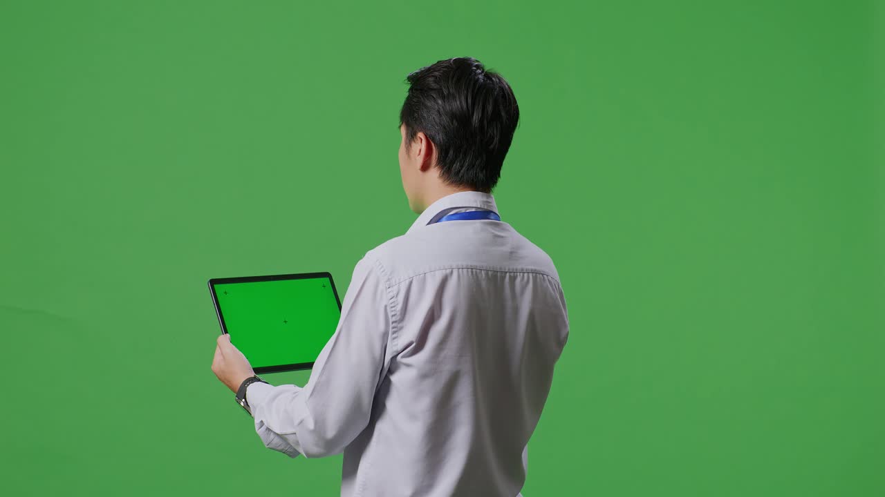 녹색 화면 앞에 태블릿을 들고 있는 사람