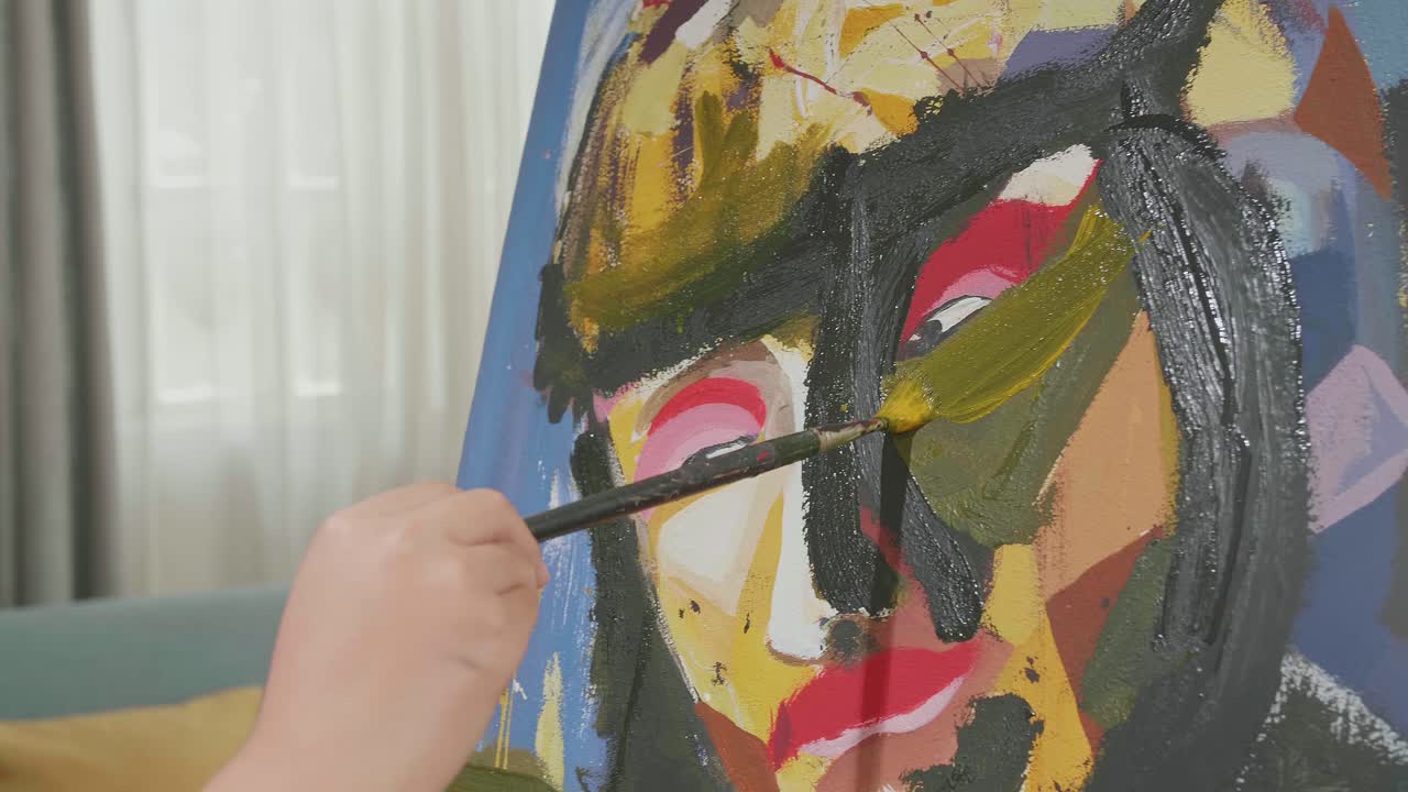 cerca de una niña de una mano sosteniendo un pincel y pintando la cara de una niño en el lienzo