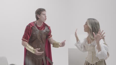 men and women wear unique roman soldier costumes at indoor studio for stock content production