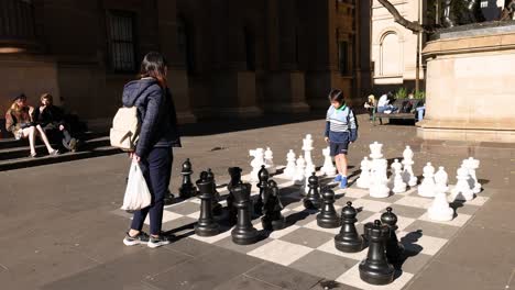 people playing giant chess outside library