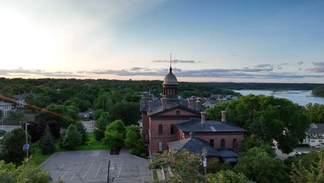 Die-Luftaufnahme-Des-Sonnenuntergangs-über-Den-Baumwipfeln-Zeigt-Das-Historische-Gerichtsgebäude-Von-Stillwater,-Minnesota