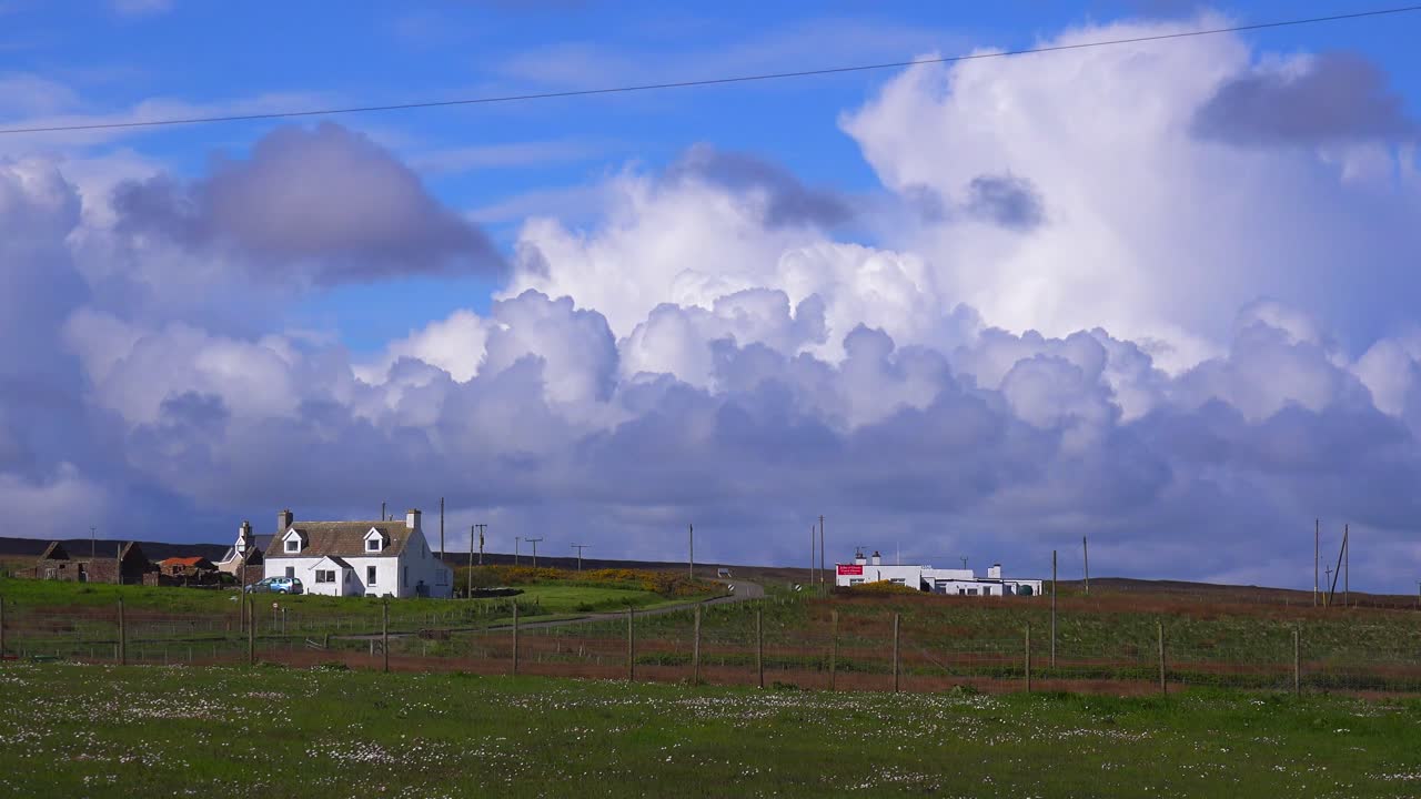 hermosas nubes tormentosas se forman detrás de un pequeño pueblo escocés cerca de john o'groats