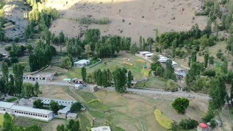 Drone-Aéreo-De-Una-Pequeña-Ciudad-Paquistaní-En-Las-Montañas-Del-Valle-De-Astore-Pakistán-En-Una-Tarde-De-Puesta-De-Sol-Durante-El-Verano