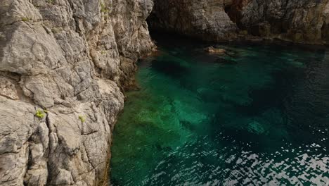 Isla-De-Kalamota,-Mar-Adriático,-Croacia---Las-Aguas-Azules-Translúcidas-Debajo-De-Los-Acantilados-Escarpados-Y-Escarpados---Toma-Aérea-De-Drones