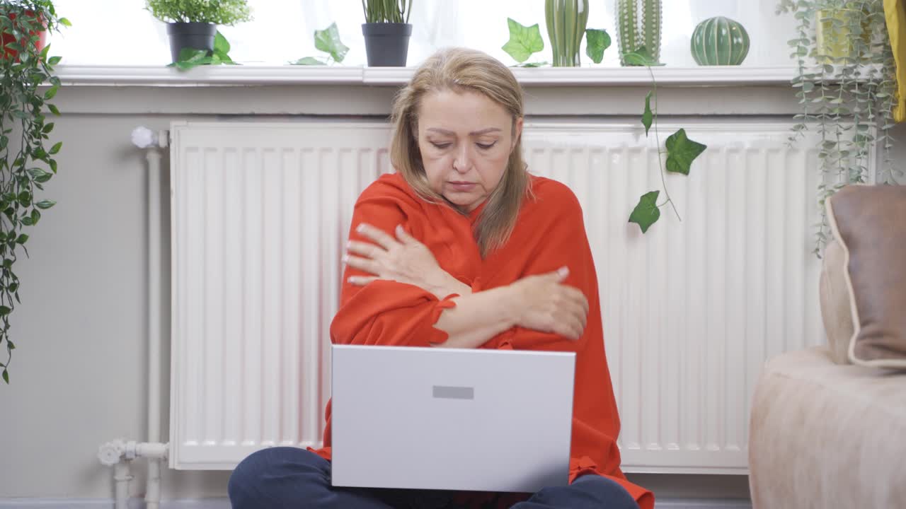 la mujer tiene frío y trata de usar una computadora portátil.