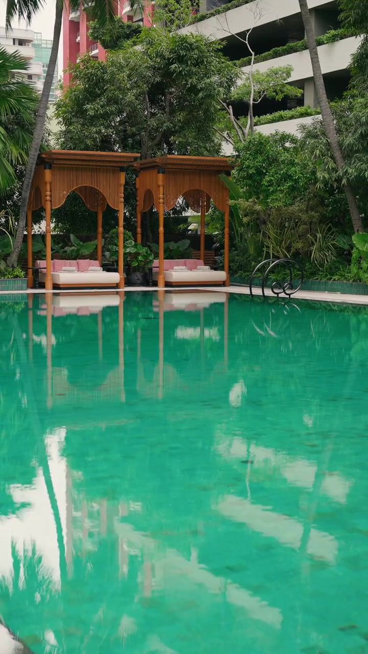 Outdoor swimming pool with luxury sun loungers, tropical gardens and ...
