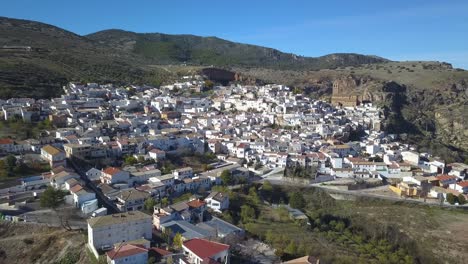 vista aérea de un pueblo blanco tradicional español en las montañas con una gran iglesia