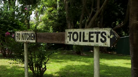 handheld view of old to kitchen and toilets sign with arrows pointing opposite