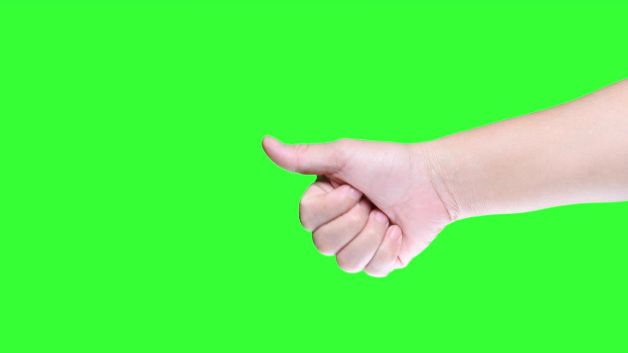Hand showing thumbs up sign against on green screen background.
