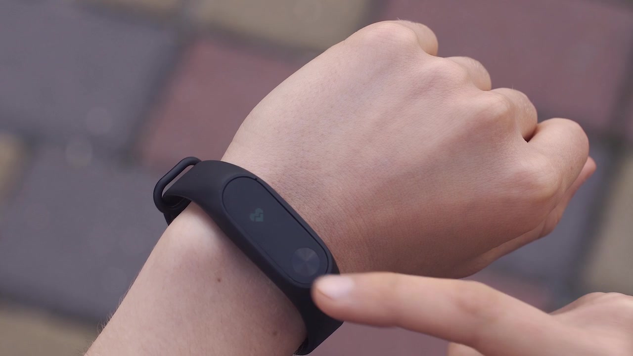 Person Checking Fitness Tracker Displaying Health Data on Wrist