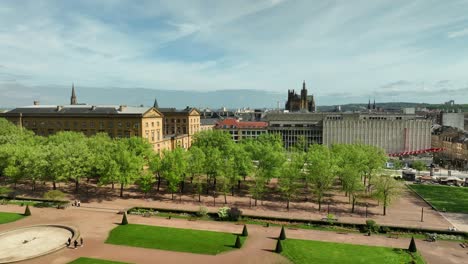 vista de avión no tripulado volando sobre los jardines de la explanada soleada revelando la ciudad de metz