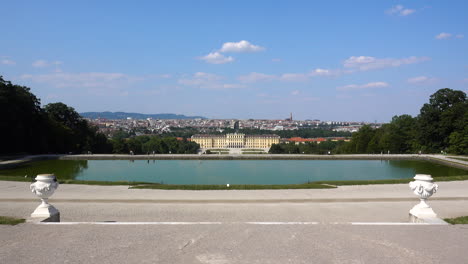 Few-people-at-Schönbrunn-grounds-with-blue-sky-and-clouds,-panoramic-view-in-distance