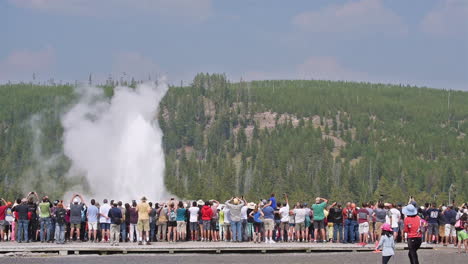 黃石國家公園 (yellowstone national park) 的老忠實噴泉 (old faithful geyser) 爆發時,有一大群遊客在觀察