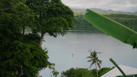 isla tranquila con un hombre remando al atardecer en moso, frente a la costa de efate en vanuatu, provincia de shefa