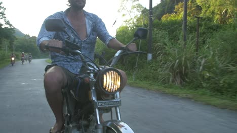 man riding a motorbike through vietnamese countryside