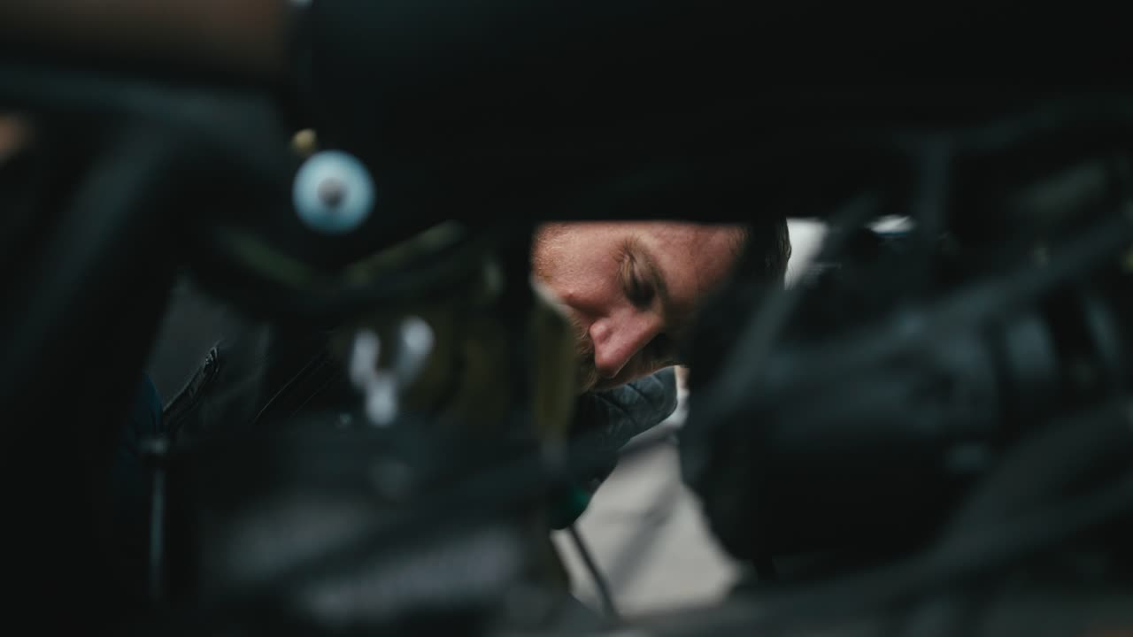 mecánico de motocicleta trabajando debajo de la bicicleta