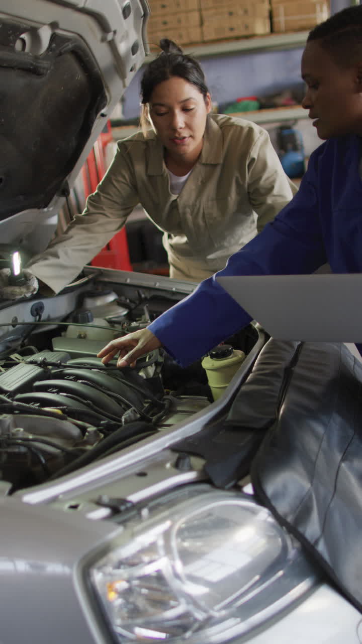 vídeo vertical de remolque de diversas mujeres mecánicas de automóviles comprobando el coche