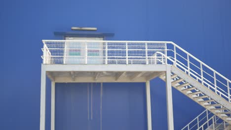 metal stairs and platform on a blue building