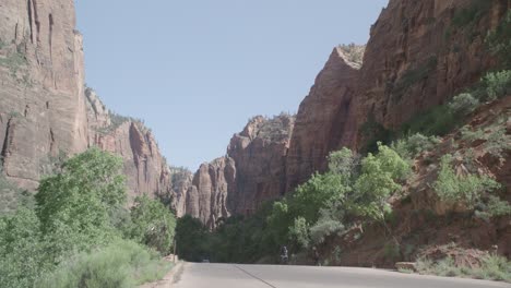 a road with a mountain range and bicyclists riding down