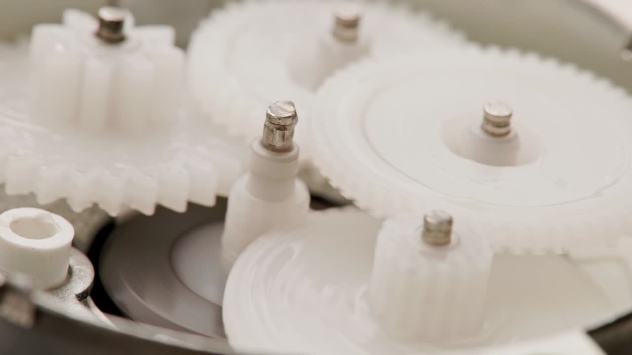 5개의 플라스틱 기어가 작은 감소 기어 안에서 상호 메쉬로 회전합니다.