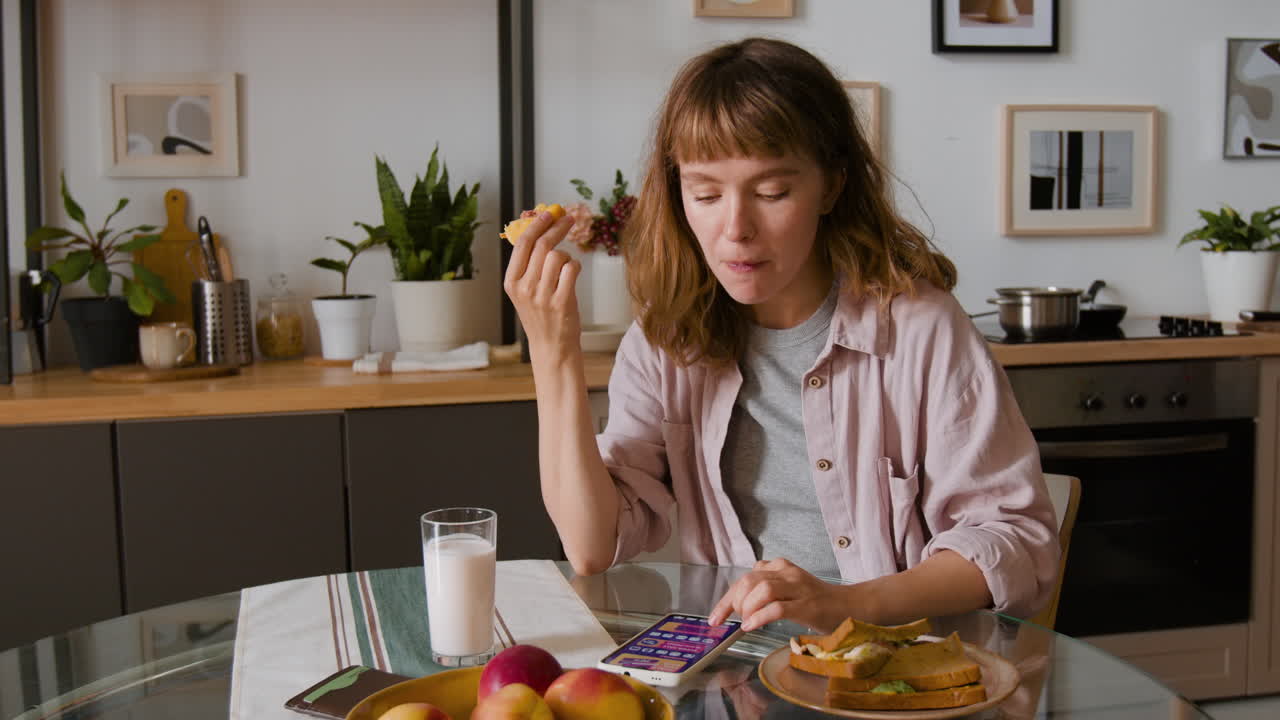 Woman Eating Breakfast with Mobile Phone
