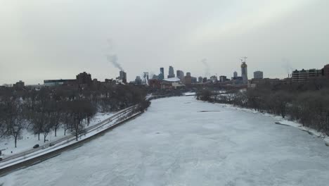 mississippi river completely frozen close to downtown minneapolis during a cloudy cold winter afternoon during a polar vortex