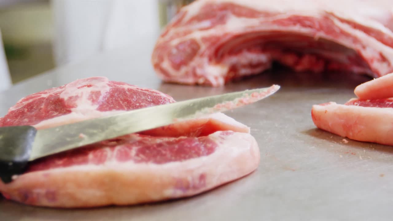 Primo piano di un coltello su carne rossa affettata